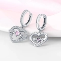 Elegant silver earrings with pink heart stones and crystal wings on a soft pink background - White Gold