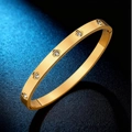 Gold-plated stainless steel bangle with sparkling clover-shaped crystal inlays - Gold
