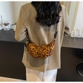 Modische Halbmondtasche mit Leopardenmuster und geknotetem Riemen am weiblichen Modell - Leopardenmuster Schwarz