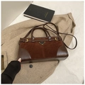 Detalle del bolso tote retro marrón oscuro con costuras de ante y placa de metal - Marrón