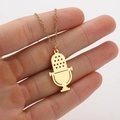 Close-up of a gold microphone pendant necklace held by hand showing detailed musical design - Microphone Gold