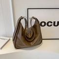 Grande borsa hobo in pelle marrone con fibbia argento in ambiente minimalista - Sabbia