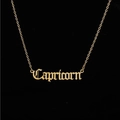 Close-up of golden Capricorn zodiac necklace with gothic style cutout lettering - Capricorn Gold