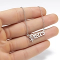 Macro detail of silver Pisces zodiac necklace with Old English gothic font pendant - Pisces Steel