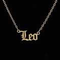 Macro shot of gold-plated Leo zodiac pendant with gothic lettering and O-link chain - Leo Gold