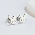 Primer plano de pendientes de conejo minimalistas en acero inoxidable pulido plata - Color Acero
