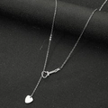 Dettaglio di una collana a forma di chitarra con ciondolo a cuore su sfondo nero moderno - Color Acciaio