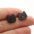 Detail view of small black cat stud earrings with hollow heart nose held between fingertips - Black Cat (661)