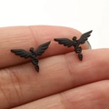 Macro view of matte black angel wing spiral stud earrings held by hand for size comparison - Black Wing DNA (663)