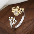Anello minimalista a nido d'ape con ape dorata e gemme gialle su sfondo legno - Stile Ape e Nido d'Ape con Zircone a Goccia (蜂巢(转动)-4)