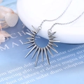 Moderne silberne Sonnenanhänger-Halskette mit spitzen Zacken an feiner Gliederkette - Weißgold