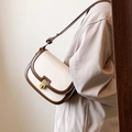 Borsa a sella bianco crema con finiture caffè scuro e tracolla regolabile sul modello - Bianco