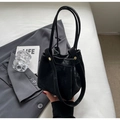 Retro-Eimerbeutel in Schwarz mit matter Textur und Golddetails auf grauem Anzug - Schwarz
