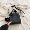Piccola borsa quadrata nera trapuntata con finiture dorate e ciondolo a pompon in peluche - Nero