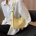 Minimalist light yellow crescent underarm bag with adjustable strap worn by a model - Yellow