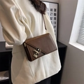 Borsa a tracolla quadrata marrone minimalista con chiusura a catena indossata da modella - Marrone