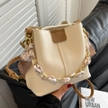 Borsa a secchiello crema con tracolla marrone e catena in seta su divano in pelle - Bianco Sporco