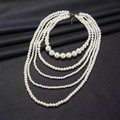 Elegante collar de perlas multicapa con seis hilos sobre fondo de cuero negro rugoso - Estilo Multicapa
