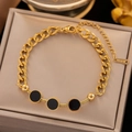Goldenes Gliederkette-Armband aus Titanstahl mit schwarzen Emaille-Anhängern auf Tablett - Runde Schwarze Muschel Stil (S655)