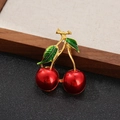 Elegant red cherry brooch with gold stem and green leaves on a dark textured background - Style 10 (Red/Green/Gold)