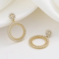 Elegante goudkleurige oorringen met sprankelende zirkonia op witte zijden achtergrond - Goud