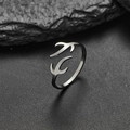 Anello aperto con rondine minimalista in metallo lucido su uno sfondo di pietra scura - Stile Uccello / Color Acciaio