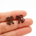Nahaufnahme kleiner schwarzer matter Einhorn-Ohrstecker mit hohlem Flügel-Design - Schwarz