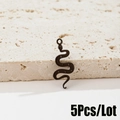 Vista dettagliata di 5 ciondoli a forma di serpente nero opaco su marmo strutturato - Serpente (485) / Nero