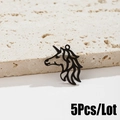 Macro de 5 colgantes de unicornio negro mate con diseño calado sobre fondo de piedra - 5 Piezas / Negro