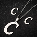 Macro view of polished stainless steel jewelry set with letter C pendant and studs - C Steel Color