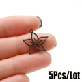 Close-up of five-petal hollow star flower pendant in matte black finish on fingers - Black