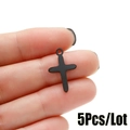 Detalle de un pequeño colgante de cruz negra entre los dedos para creación de joyas - 5Piezas/Lote / Negro
