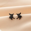 Dettaglio macro di orecchini a lobo Chihuahua neri opachi su sfondo in tessuto morbido - Nero