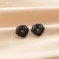 Macro shot of gold dog silhouette earrings with black enamel on a silk background - Black