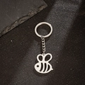 Polished stainless steel honey bee pendant keychain on black textured surface - Little Bee Style (166)
