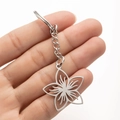 Detailed close-up of a silver stainless steel flower pendant keychain with petal texture - Steel