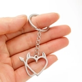 Polished stainless steel devil heart keychain with horns and tail held by a hand - Devil Heart Style (168)