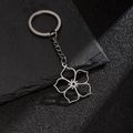 Silver stainless steel keychain featuring a hollow five-petal flower pendant on dark slate - Spiral Five-Petal Flower (198)