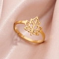 Golden adjustable maple leaf ring with cutout design on an elegant pink satin background - Gold
