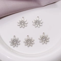 Five pieces of matte stainless steel flower charms for DIY jewelry making on white ceramic - Steel