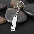 Polished stainless steel rectangular keychain with hollow letter L over dark pebbles - Letter L