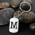 Polished silver stainless steel keychain with engraved letter M on a dark textured surface - Letter M