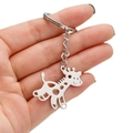 Main tenant un porte-clés pendentif girafe minimaliste en acier inoxydable poli sur blanc - Style Girafe (050)