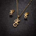 Conjunto de joyas de geco dorado con collar y pendientes sobre fondo de cuero negro pro - Dorado