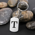 Polished stainless steel keychain with cutout letter T pendant on smooth stones - Letter T
