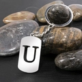Polished stainless steel keychain featuring a hollow letter U on dark pebble stones - Letter U