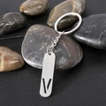 Polished stainless steel rectangular keychain with hollow letter V on grid background - Letter V