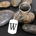 Polished stainless steel keychain with letter W charm on smooth pebbles - Letter W