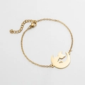 Detalle del colgante dorado con silueta de luna y gato en una pulsera de eslabones finos - Dorado
