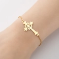 Detail of a gold hollow cross pendant bracelet with intricate geometric patterns on a model - Vintage Floral Hollow Cross (4)-Gold